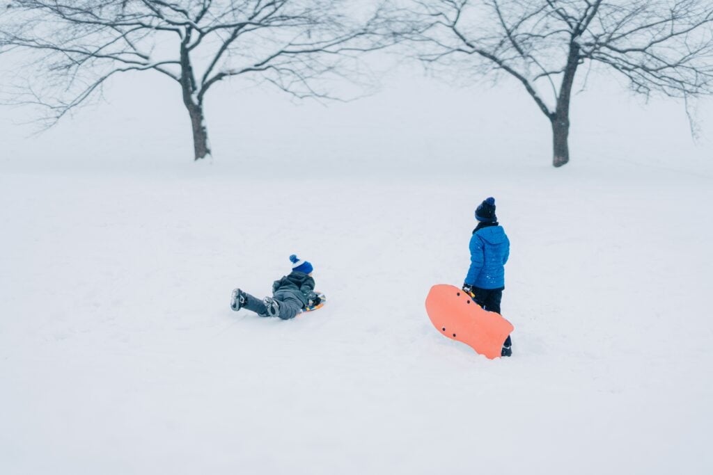 Deux enfants glissant sur la neige,
activités hivernales