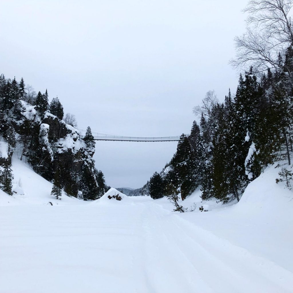Passerelle au dessus du Lac La Haie dans le Parc national d'Aiguebelle, en Abitibi-Témiscamingue, lors du Défi Hiver 2019. Paysage hivernal, le lac est gelé et recouvert de neige.