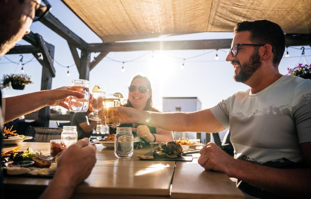 L'un des trésors agroalimentaires : Le Prospecteur. On y voit des amis en train de profiter d'un bon repas sur la terrasse.