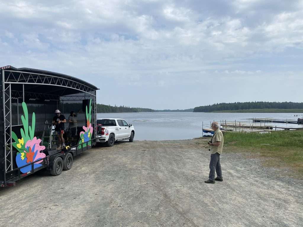 La scène ambulante d'Au pays des pick-up est accrochée à un camion et se fait installer sur le bord du lac Flavrian.