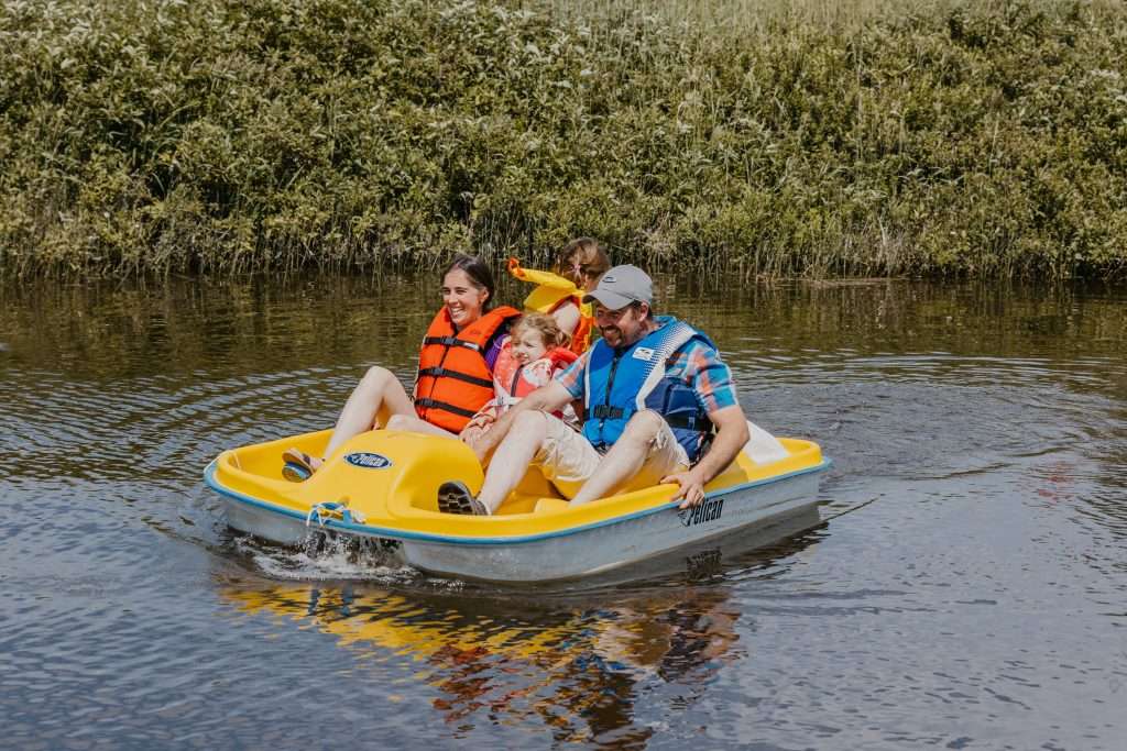 La photo présente une famille en train de faire du pédalo sur la rivière Harricana.