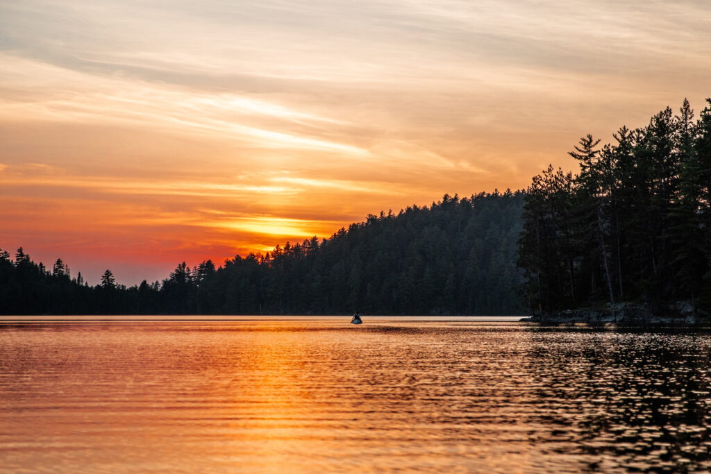 Personne en canot sur le lac Kipawa au couché du soleil. 